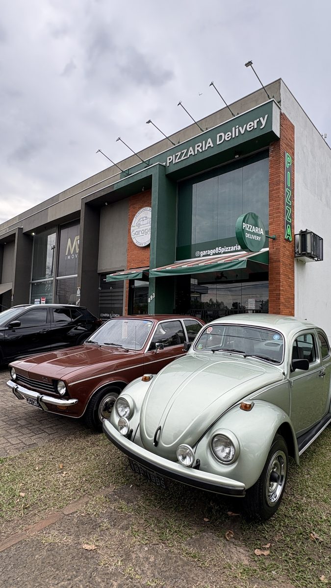 Fusca creme estacionado na frente da Garage85 durante o encontro