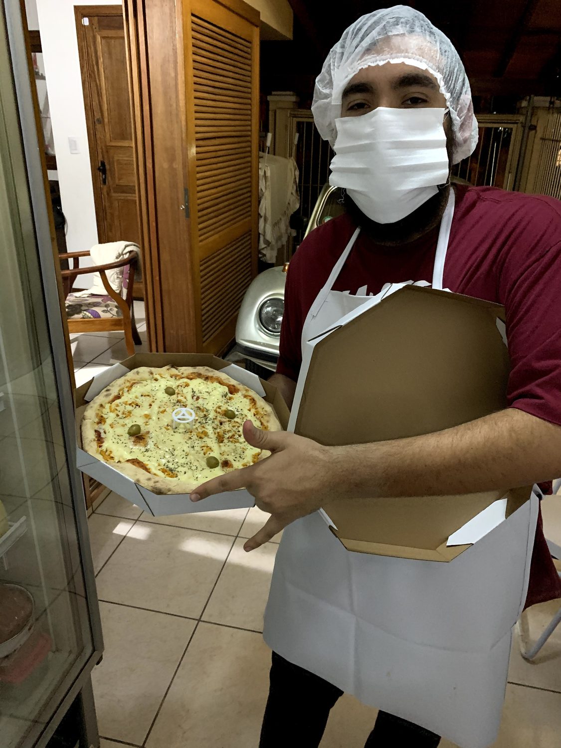 Pizzaiolo da Garage85 com uma pizza recém-saída do forno